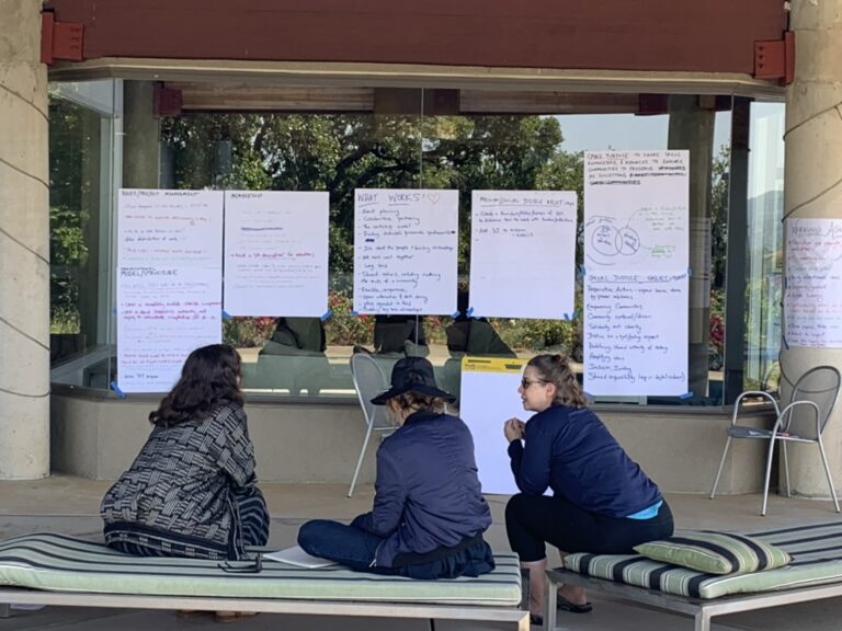 Three members of the strategic planning group work on objectives during the retreat in June 2023.