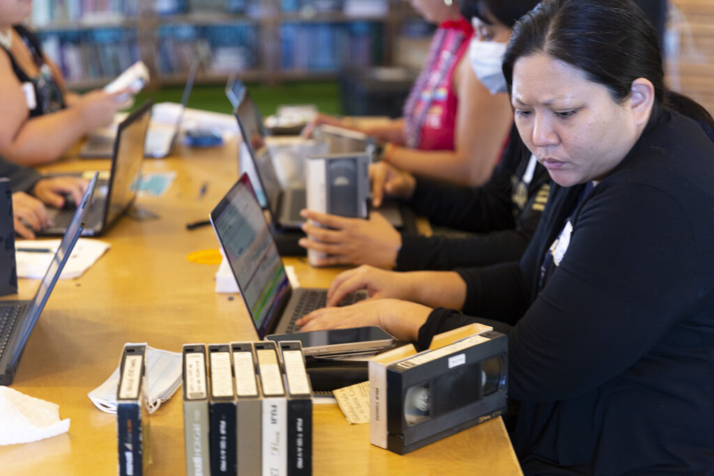 Image from 2023 workshop in Honolulu. Inventorying collection of video tapes on a table.